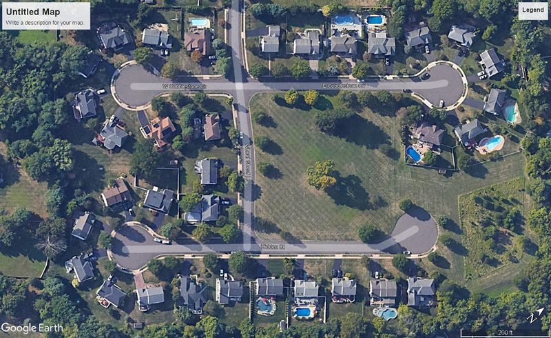 Aerial view of a completed community of homes around two cul-de-sacs
