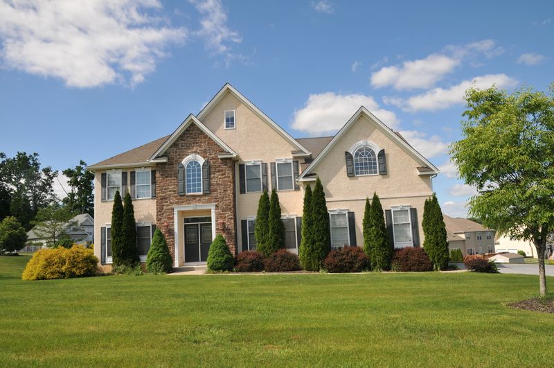 Colonial with a stone entry and stucco walls