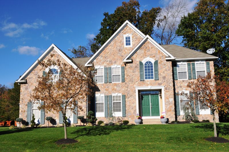 Stone-front home with twin gables and a green front door