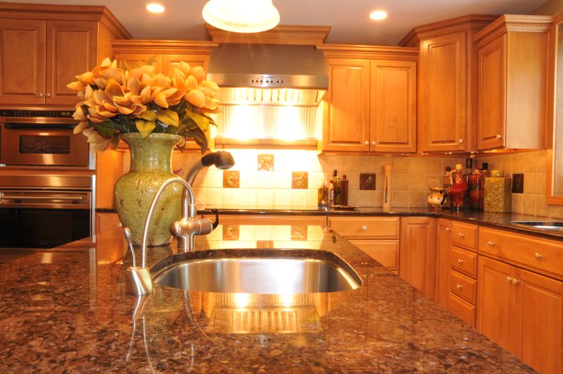 Granite island with an undermount sink, facing the range hood