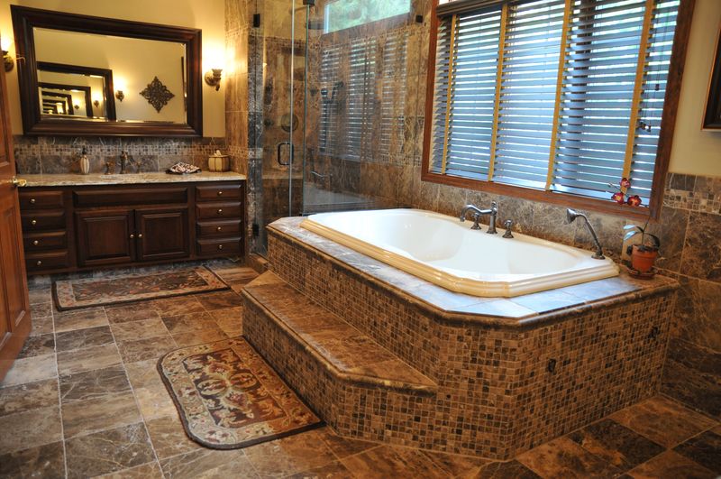 Tiled soaking tub beside a glass shower