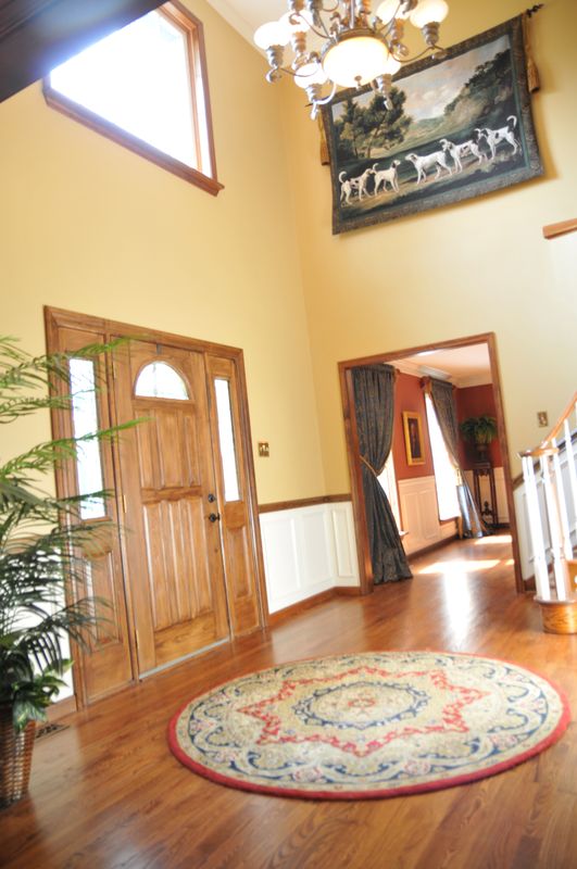 Two-story foyer with a chandelier and hardwood floors