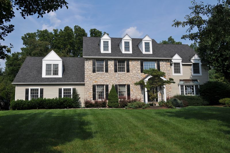 Colonial with a real stone front, three dormers and a covered entry